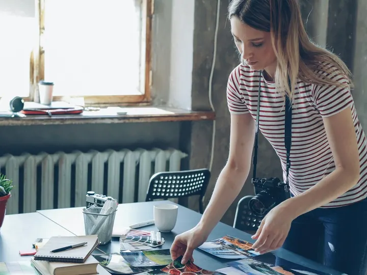 A woman laying out prints on her workshop table